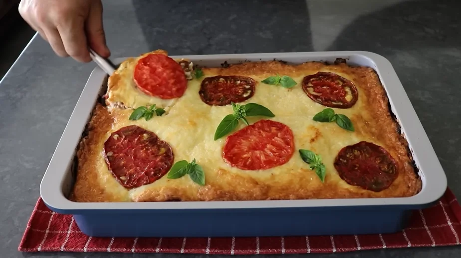 Southern tomato Frito pie baked golden with tomato slices and basil