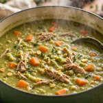 Split pea soup with smoked turkey and carrots in a green Dutch oven